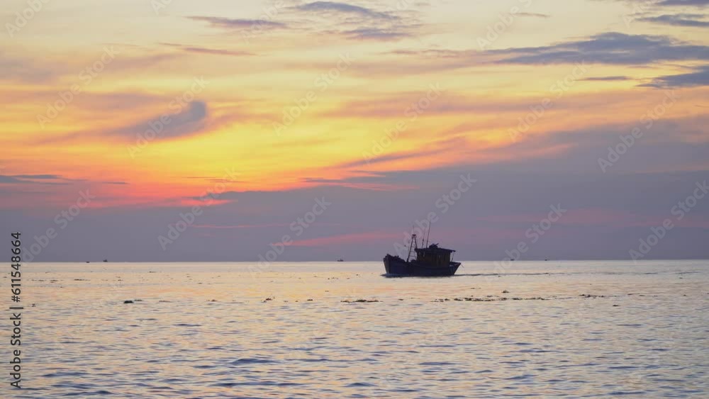 Landscape on the sea at dawn with silhouettes of Vietnamese fishermen's fishing boats running towards the port, against a background of bright yellow cloudy sky. Seascape sunrise and sunset. Landscape on the sea at dawn with silhouettes of Vietnamese fishermen's fishing boats running towards the port, against a background of bright yellow cloudy sky. Seascape sunrise and sunset.