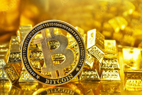Bitcoin stand with the stacking gold bars background. Bitcoin is one of cryptocurrency or digital asset for digital payment that uses cryptography to secure transaction photo