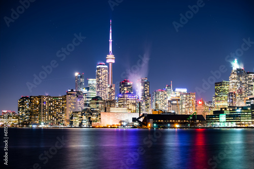 A full moon rising over Toronto Canada. Beautiful long exposure colourful night scene reflection in water