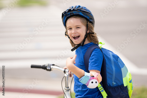 Little kid boy ride a bicycle in the park. Kid cycling on bicycle. Happy smiling child in helmet riding a bike. Boy start to ride a bicycle. Sporty kid bike riding on bikeway. Kids bicycle.