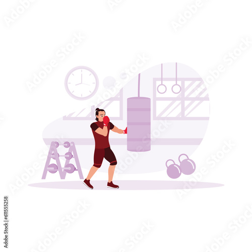 Male boxer, enthusiastically punching a punching bag in front of him in a modern gym complete with sports facilities and a wall clock to indicate the time. Trend Modern vector flat illustration.