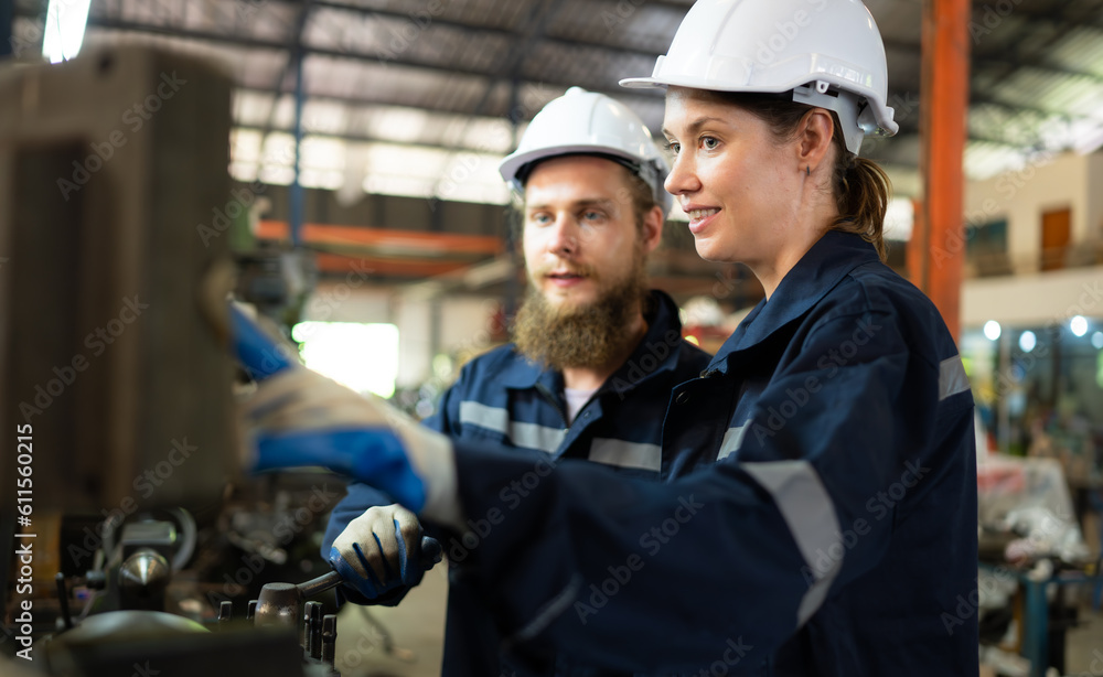 Both of mechanical engineers are checking the working condition of an old machine that has been used for some time. In a factory where natural light shines onto the workplace Both of mechanical engineers are checking the working condition of an old machine that has been used for some time. In a factory where natural light shines onto the workplace