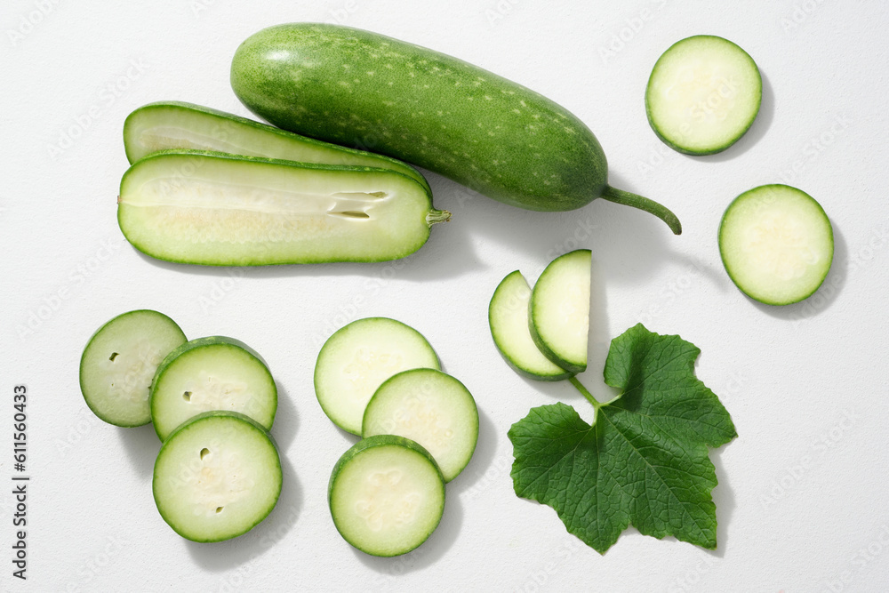 Top view, creative flat lay shot of winter melon slices and leaf decorated on white background. Parts of winter melon as: skin, flesh, seeds, leaves and flowers can all be used for food and medicine. Top view, creative flat lay shot of winter melon slices and leaf decorated on white background. Parts of winter melon as: skin, flesh, seeds, leaves and flowers can all be used for food and medicine.