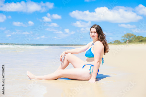 ビーチに座るセクシーな水着姿の白人の女の子 © photok