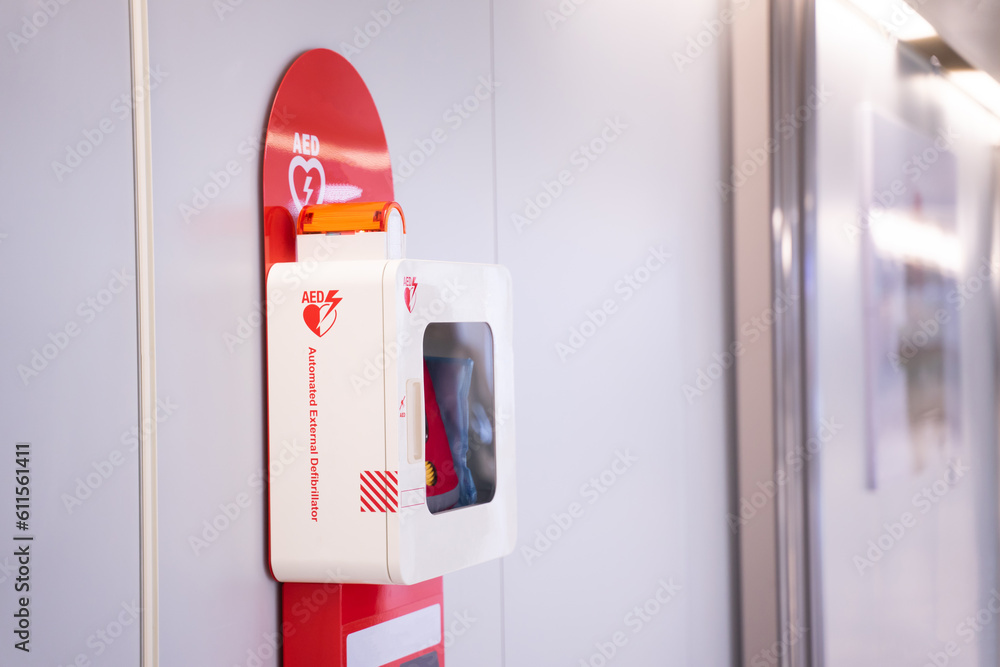 Automatic external defibrillator mounted on white wall - obrazy, fototapety, plakaty 