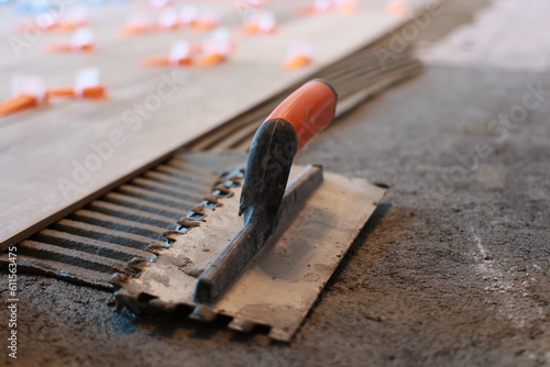 Pose de carrelage au sol par un artisan dans une maison