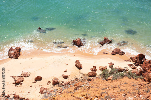 Ocean sandy beach with rocks and turquoise water. Top View