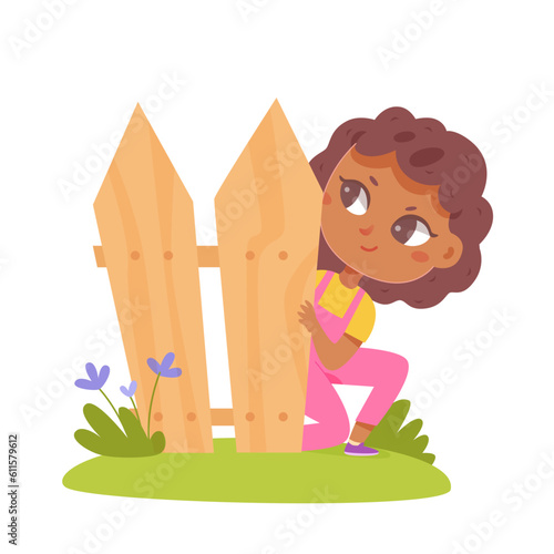 Cute girl peeping over fence, summer backyard scene with hiding funny happy child