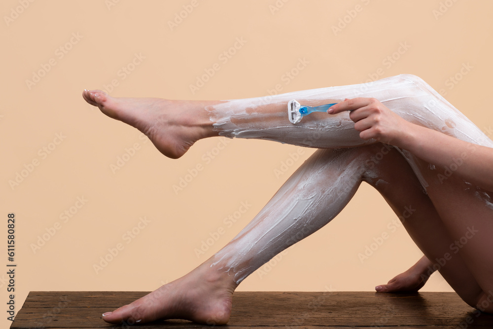 Sexy woman shaving legs. Hygiene skin body care concept. Hair removal