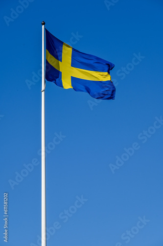 Swedish flag on flag pole and clear blue sky