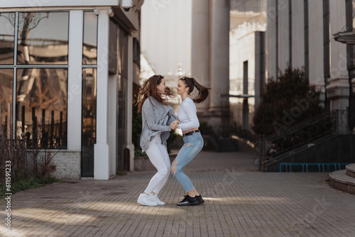 Photo of two young girls enjoying a sunny day and playing together on the city streets © qunica.com