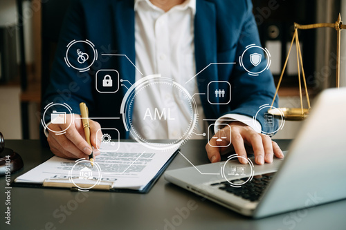 AML Anti Money Laundering Financial Bank Business Concept. judge in a courtroom using laptop and tablet with AML anti money laundering icon on virtual  screen. . photo