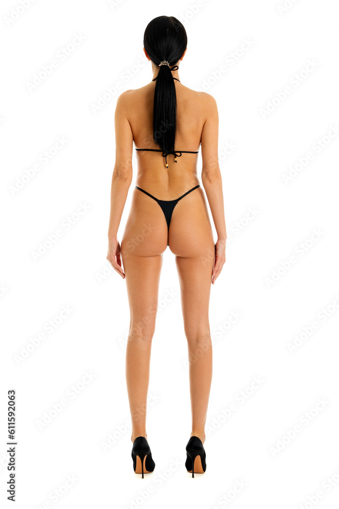 Fototapeta premium Back view of young woman in black bikini, isolated on white background