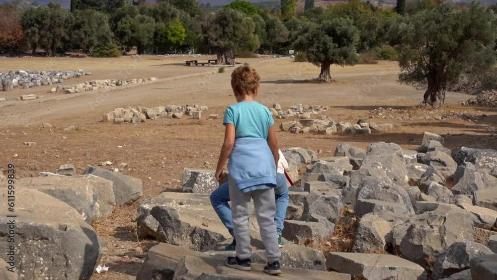 Travel with people. Caucasian father and his child boy or girl exploring together ancient landmark ruin public park summer. Kid happily jumping on stones. Family together leisure time activities. Travel with people. Caucasian father and his child boy or girl exploring together ancient landmark ruin public park summer. Kid happily jumping on stones. Family together leisure time activities.