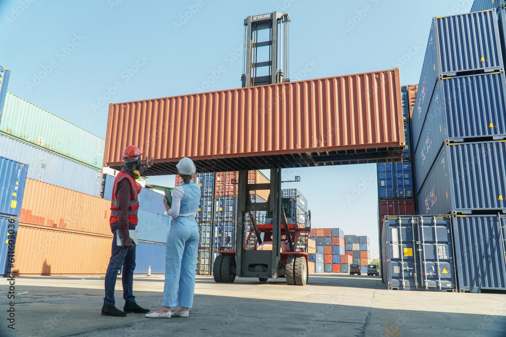 Fototapeta premium group of two african american engineer man and inspector Caucasian woman talking and checking list inventory by tablet computer loading Containers box at warehouse logistic in Cargo. diversity worker
