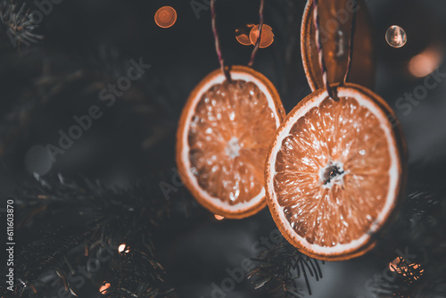 Dried orange decoration on christmas tree. Zero waste christmas concept. Christmas tree decorated with ornaments made of natural materials - slices of dried orange. Toned photo. photo