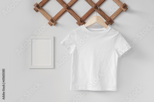 Minimalist white kid t-shirt mockup for presentation cute child sublimation designs in scandinavian boho interior with minimalistic handmade decoration and dried palm leaf
