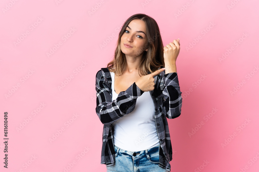 Young Romanian woman isolated on pink background making the gesture of being late Young Romanian woman isolated on pink background making the gesture of being late