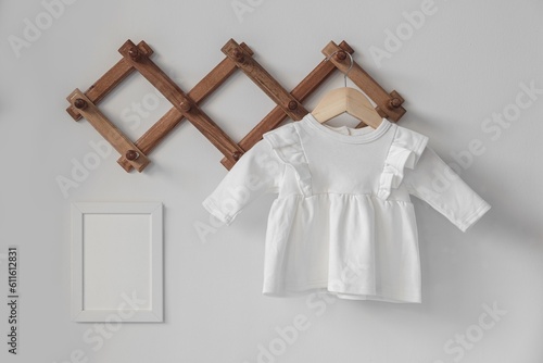 Minimalist white baby girl dress with long sleeve mockup for presentation cute sublimation designs in scandinavian boho interior with minimalistic handmade cozy decoration and dried palm leaf © Julia