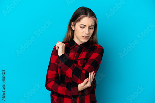 Young caucasian woman isolated on blue background with pain in elbow