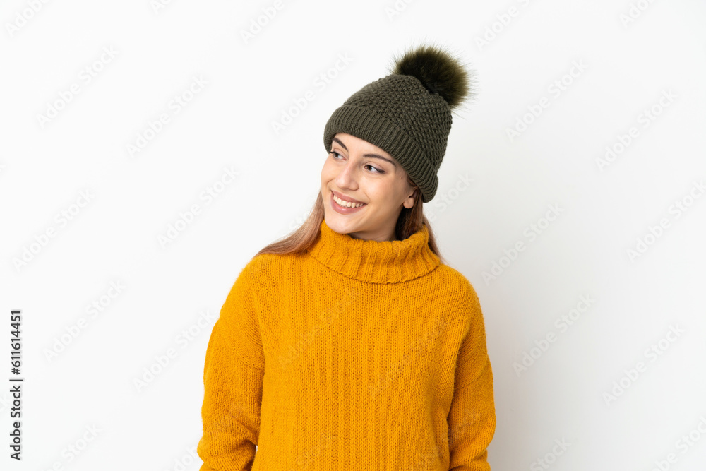 Young girl with winter hat isolated on white background looking to the side and smiling Young girl with winter hat isolated on white background looking to the side and smiling