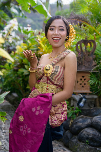Young woman dressed in Balinese costume in the garden and crazy expression