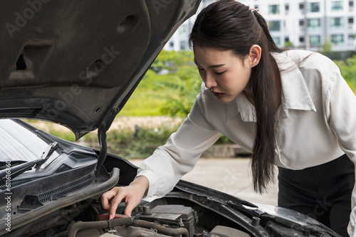 Office woman driver checking with opened hood car problem on the road, auto breakdown and repair service