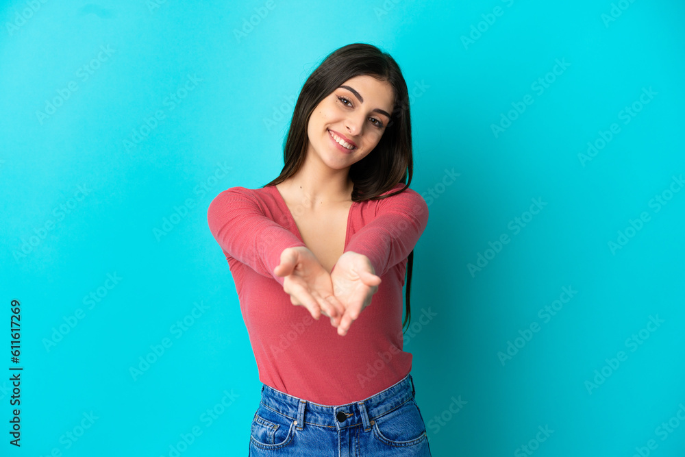 Young caucasian woman isolated on blue background holding copyspace imaginary on the palm to insert an ad Young caucasian woman isolated on blue background holding copyspace imaginary on the palm to insert an ad