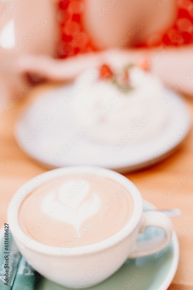 Charming woman in a restaurant, cafe on the street. She sits at the table and eats a cake with a fork. Dressed in a red sundress with white polka dots. Charming woman in a restaurant, cafe on the street. She sits at the table and eats a cake with a fork. Dressed in a red sundress with white polka dots.