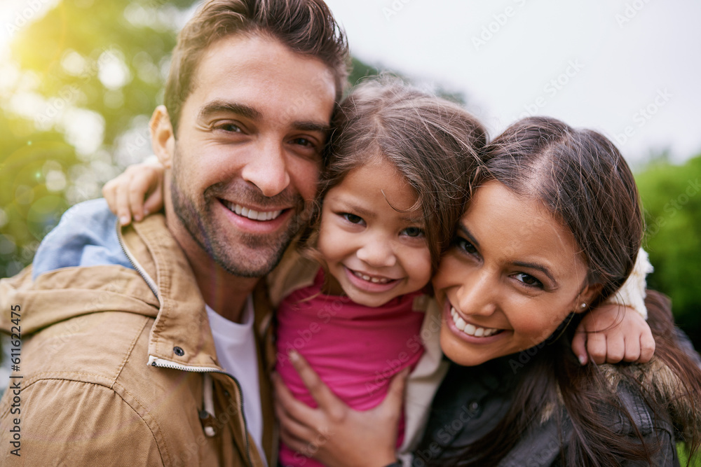 Family, closeup and park hug portrait with a mom, dad and girl together with happiness and smile. Outdoor, face and vacation of mother, father and kid with bonding, love and child care in nature