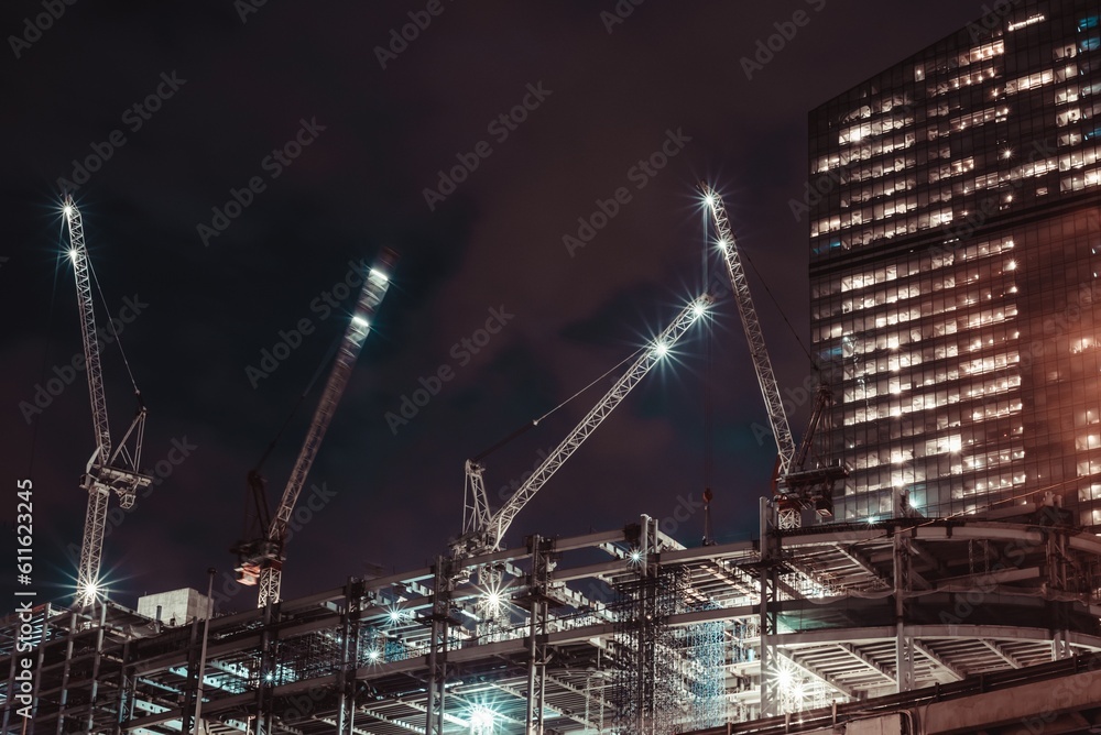 Moscow, Russia - 8 June 2023: Night photo of a skyscraper under construction in the center of Moscow, on the roof of which there are large cranes, Moscow City.