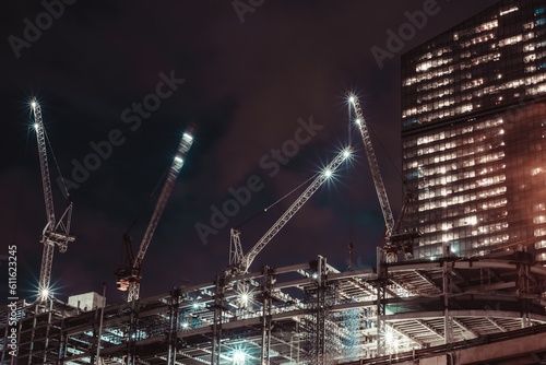 Moscow, Russia - 8 June 2023: Night photo of a skyscraper under construction in the center of Moscow, on the roof of which there are large cranes, Moscow City.