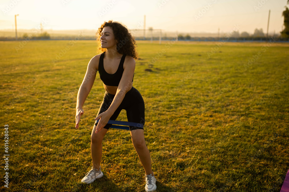 woman goes in for sports with an elastic band on her legs, exercises with a rubber band. woman goes in for sports with an elastic band on her legs, exercises with a rubber band.