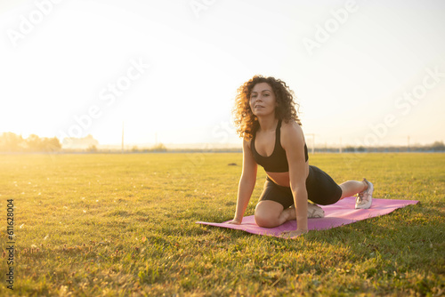 Wallpaper Mural woman goes in for sports in the stadium on a gymnastic mat at dawn. Torontodigital.ca