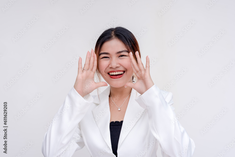 A beaming and joyful young lady yelling with cupped hands while looking at the camera. Isolated on a white background. A beaming and joyful young lady yelling with cupped hands while looking at the camera. Isolated on a white background.