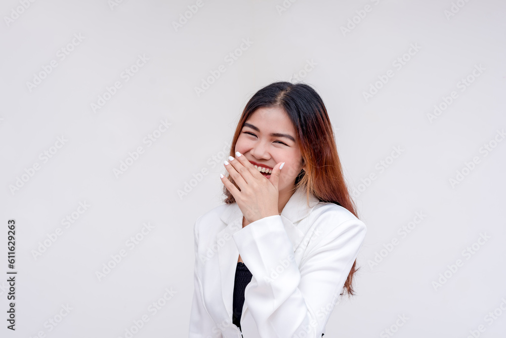 A bashful and happy young woman looking at the camera with one hand covering her mouth. Isolated on a white background. A bashful and happy young woman looking at the camera with one hand covering her mouth. Isolated on a white background.