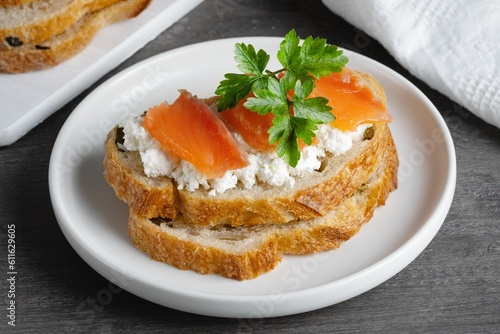 Sandwich with salted salmon and cottage cheese on a gray wooden table