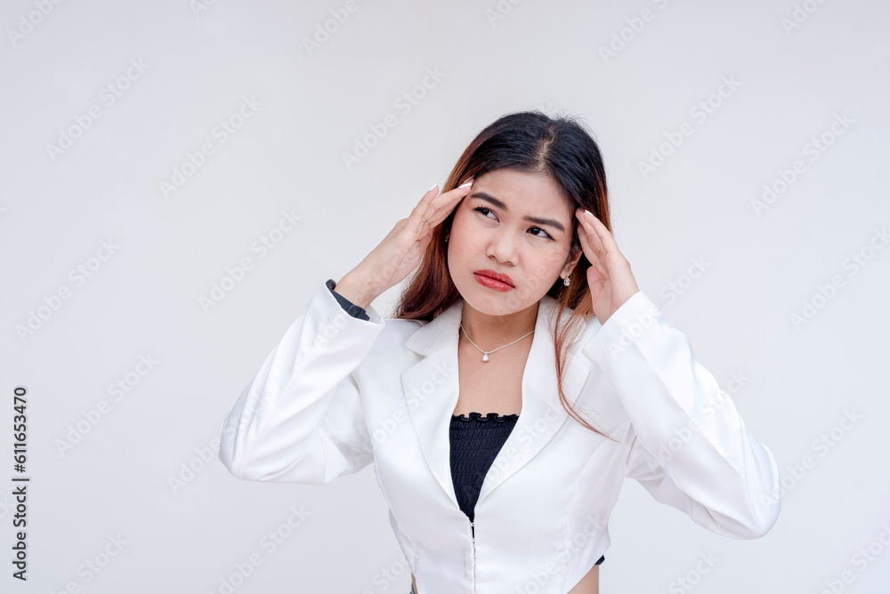 A distressed and ill young woman massaging her head to relieve herself from headache. Isolated on a white background. A distressed and ill young woman massaging her head to relieve herself from headache. Isolated on a white background.