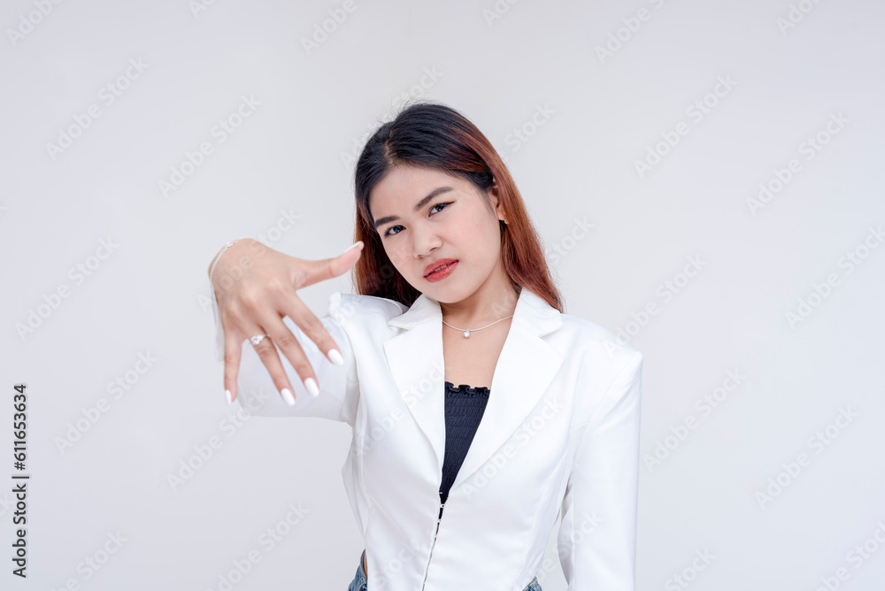 An annoyed and irritated young woman showing her engagement ring at the camera. Isolated on a white background. An annoyed and irritated young woman showing her engagement ring at the camera. Isolated on a white background.