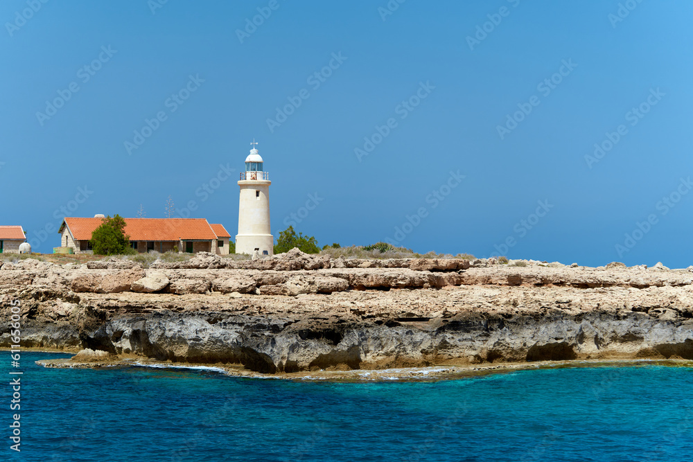 Horizontal view from sea to lighthouse on the rock. Landscape with turquoise sea water