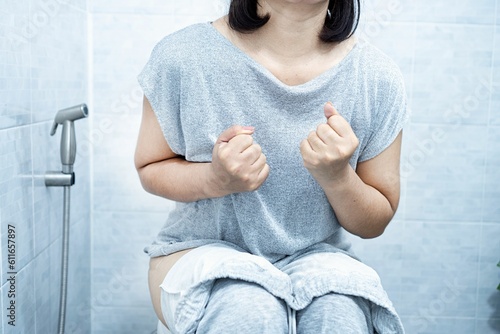 woman have problem with chronic constipation, bowel movement is painful sitting in toilet;
