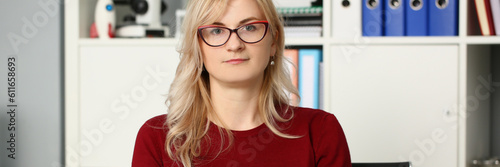 Portrait of businesswoman in glasses at workplace in office. Secretary manager and business assistant concept