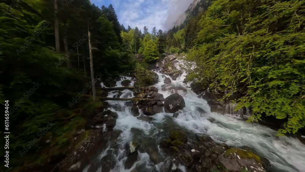 Flying close over a cascading waterfall in mountain landscape. Flying close over a cascading waterfall in mountain landscape.