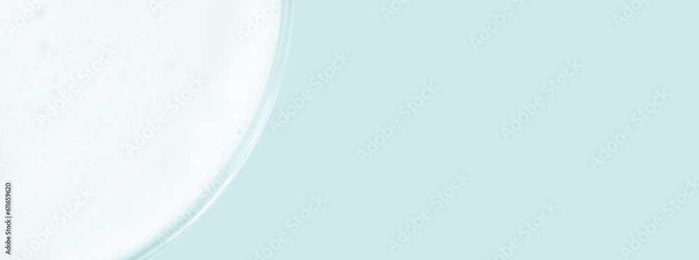 Washing agent foam in a Petri dish. On a blue background. Washing agent foam in a Petri dish. On a blue background.