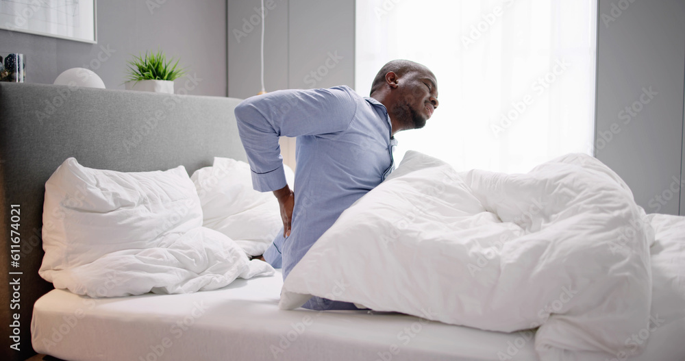 Man Sitting On Bed Suffering