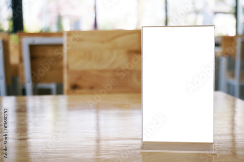 Mock up Menu frame standing on wood table in Bar restaurant cafe. space for text