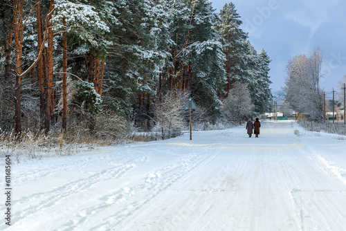 Forest and women.Winter landscape and two women for a walk.Snowy road in the countryside from Ukraine in winter.