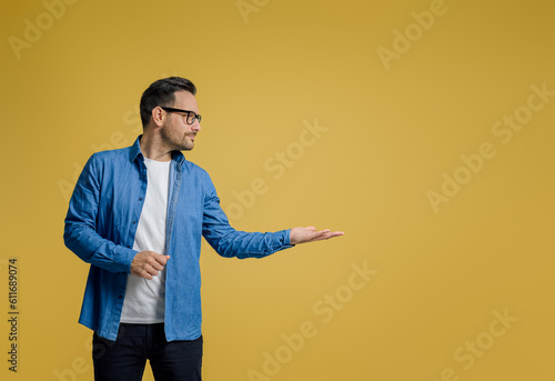 Φωτογραφία Confident businessman marketing new product on palm with copy space against yell