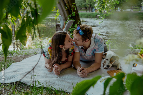 Couple in love with dog on picnic on lawn photo