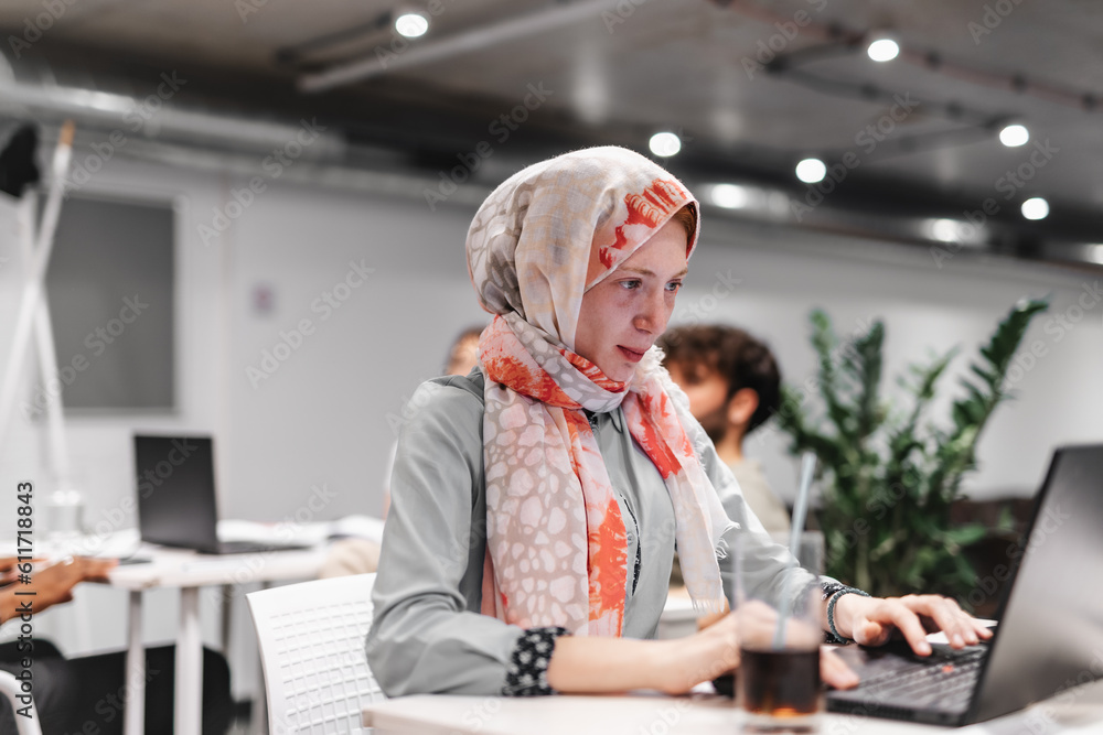 Girl in hijab working on her laptop Stock Photo | Adobe Stock